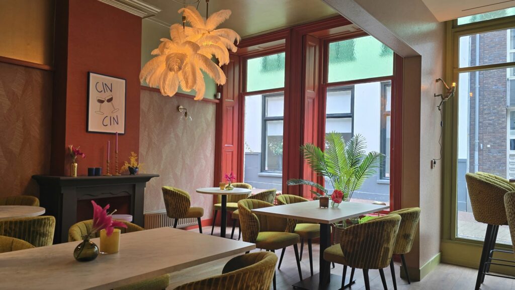 Warme zithoek met groene fauteuils bij The Gallery Foodbar in Winterswijk