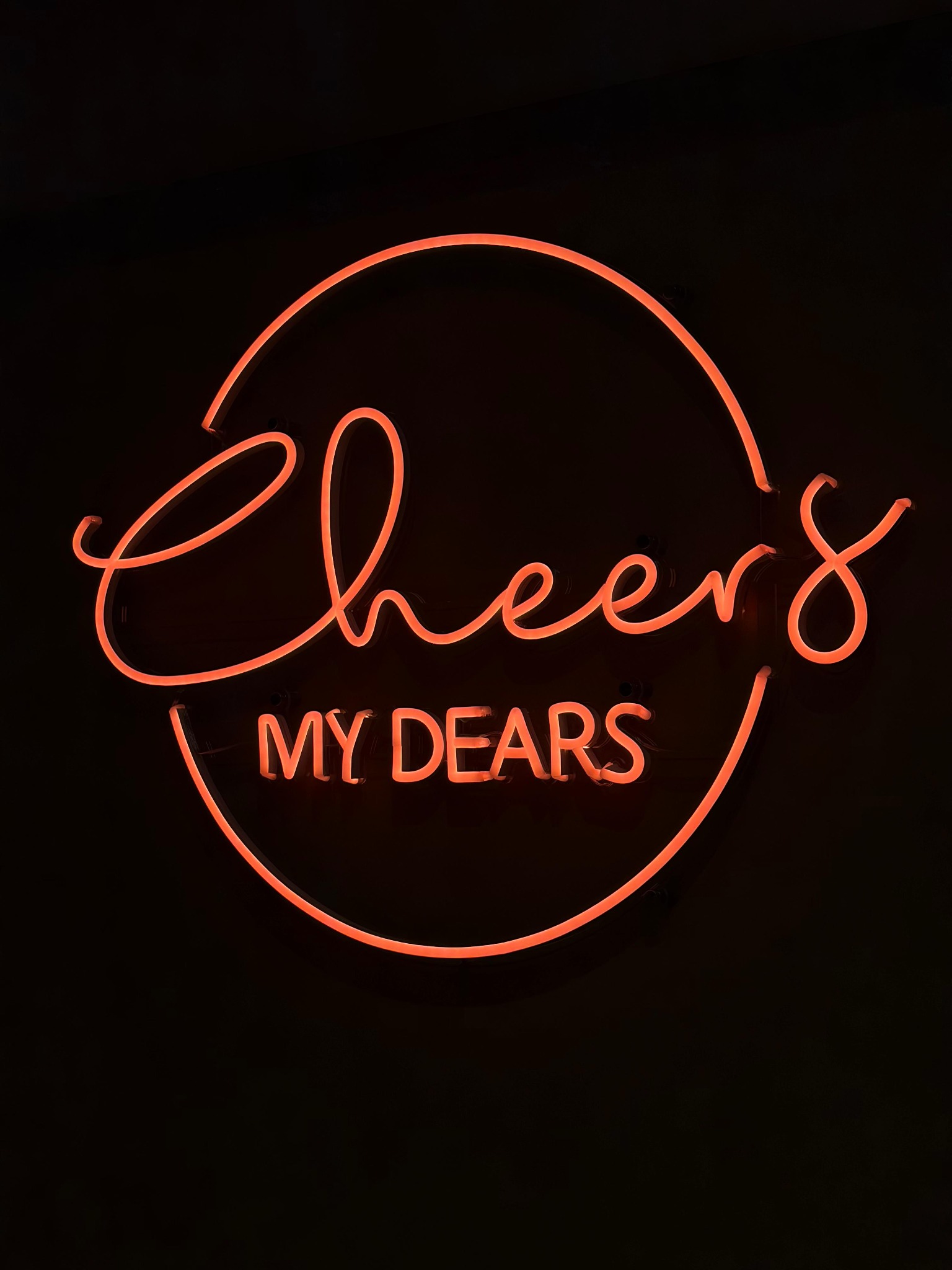 Koraalrood neonbord met de tekst Cheers my dears bij The Gallery.